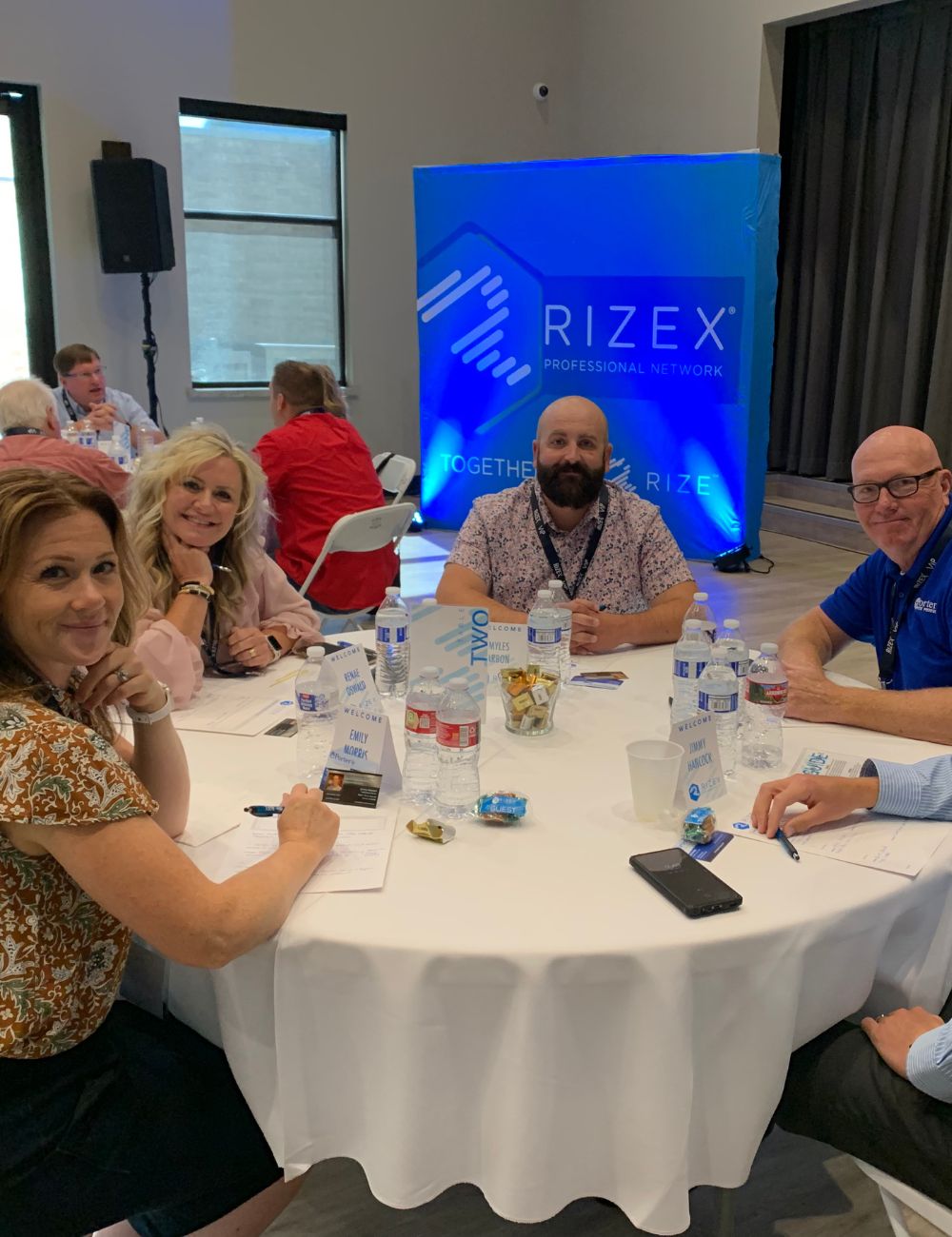 Group on Business Owners Sitting at Table and Smiling During Idaho Networking and Mastermind Event